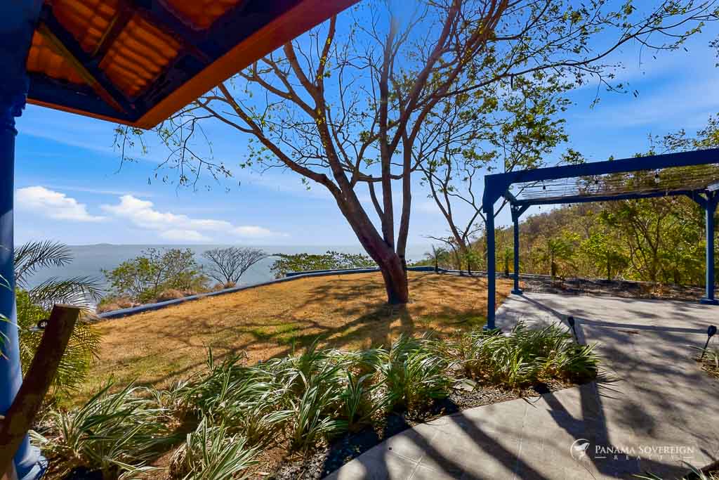 Outdoor terrace and garden area with pergola, trees, and ocean views in Bucaro Panama property