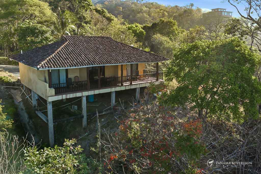 Casa elevada sobre pilotes con terraza amplia y rodeada de vegetación