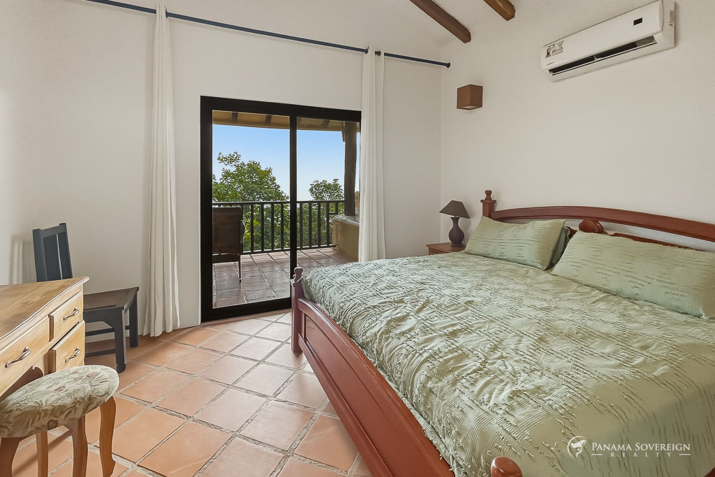 Habitación con salida a balcón, cortinas blancas y vista hacia la naturaleza