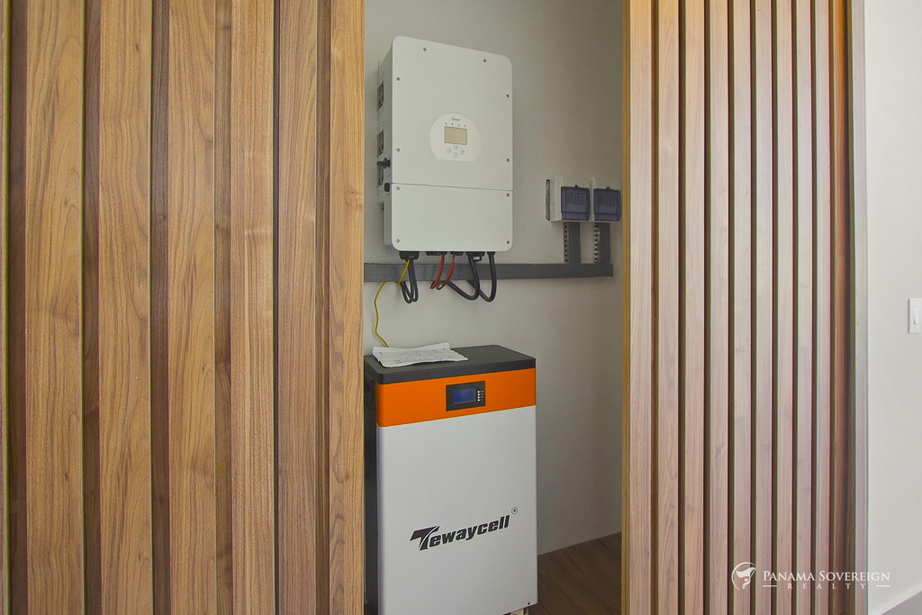 Cuarto técnico con sistema de batería Tewaycell, inversor y componentes eléctricos detrás de puertas de madera