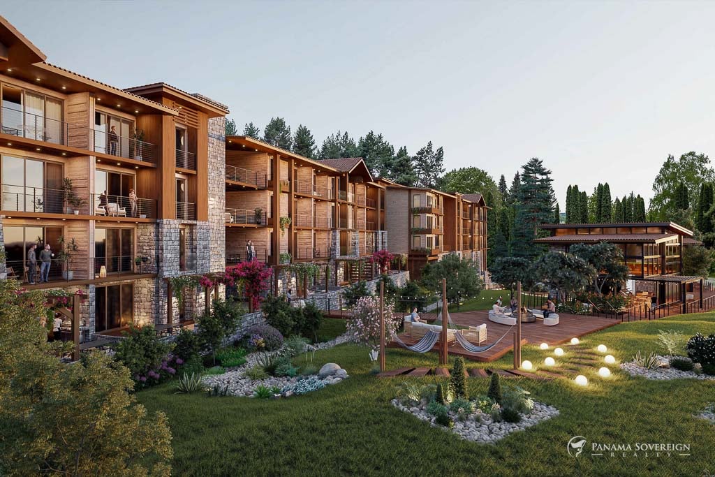 Outdoor communal area at Pinoalto, featuring vibrant gardens, a wooden deck with hammocks, and seating areas for relaxation.