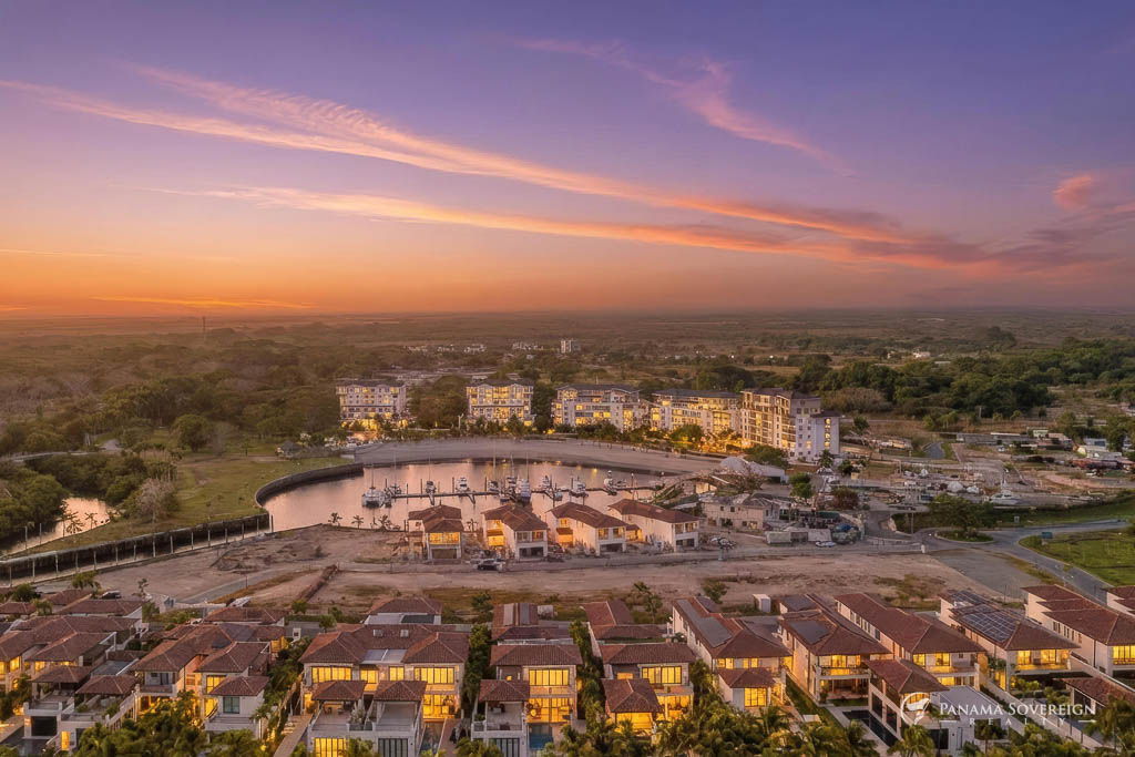Sunset aerial of Marina Village Buenaventura with illuminated residences and marina basin