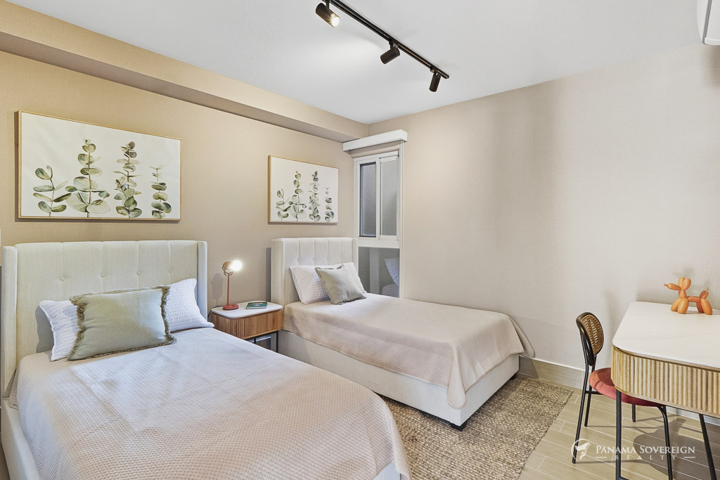 Bedroom with two twin beds, soft neutral decor, and framed botanical artwork.