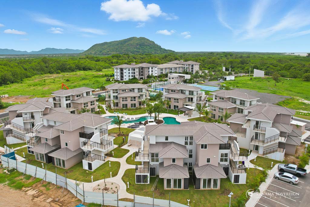 Elevated view of the community with recreational courts and surrounding greenery in the background.