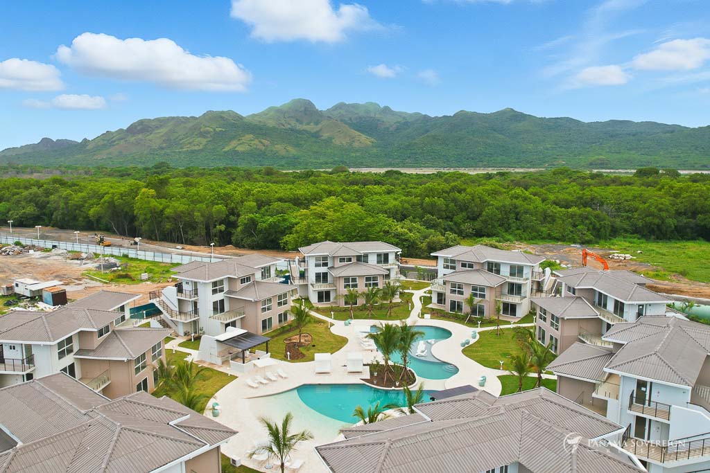 Perspective emphasizing the pool and open pathways between residential clusters.
