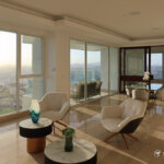 Bright living space in Santa Maria condo at sunset with stylish chairs, marble coffee tables, and expansive window views.