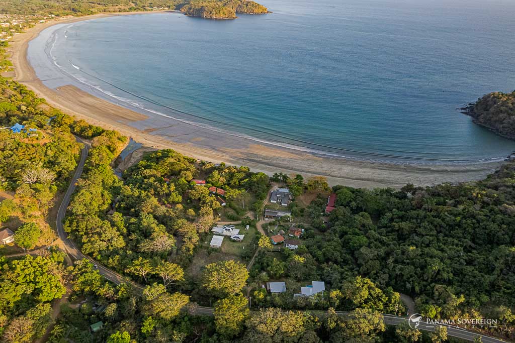 Vista en altura de la costa de Playa Venao, con la parcela enclavada en un exuberante entorno tropical cerca del agua.